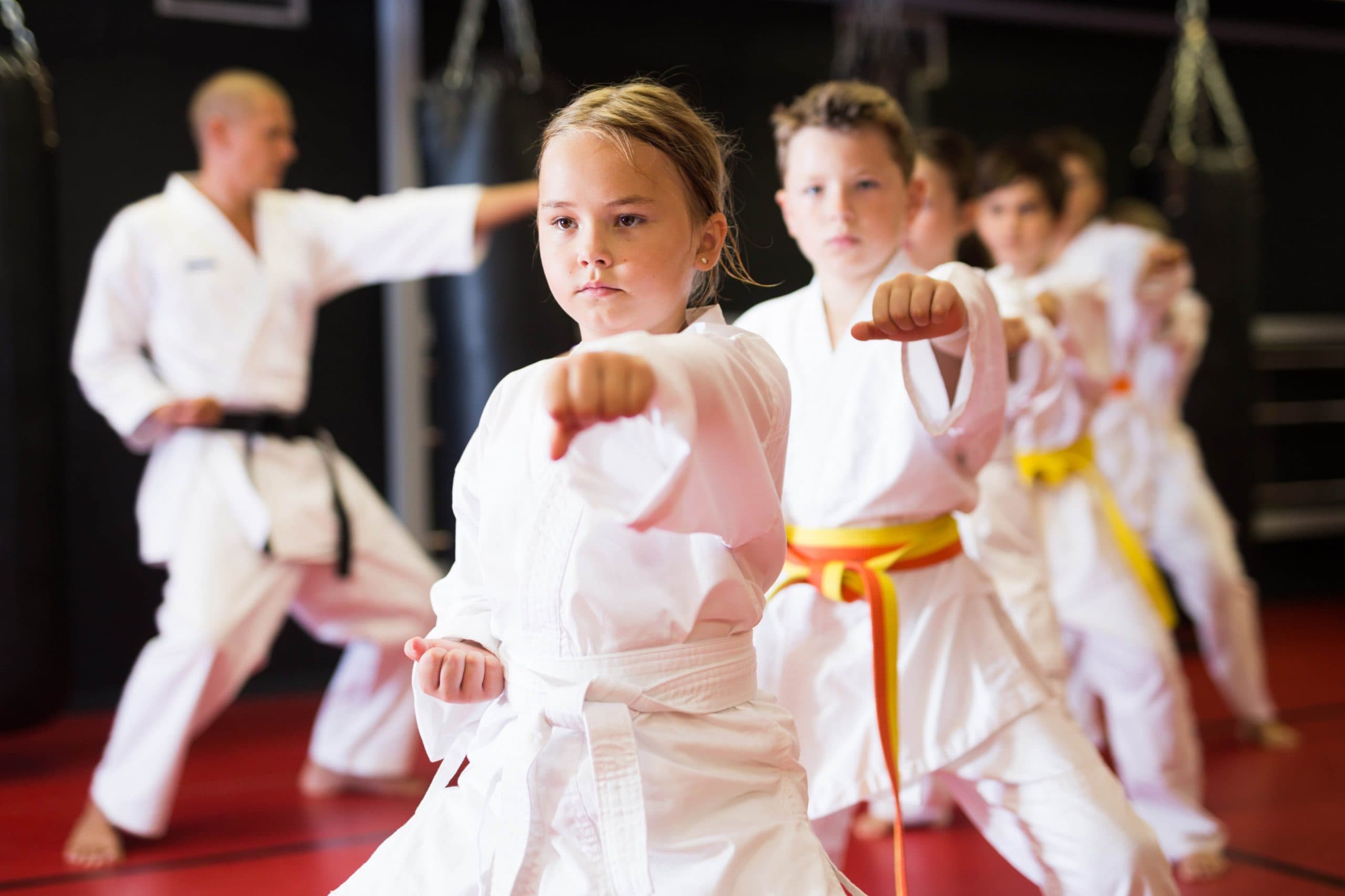 Martial arts instructor communicating with parents and kids martial arts students at a martial arts school