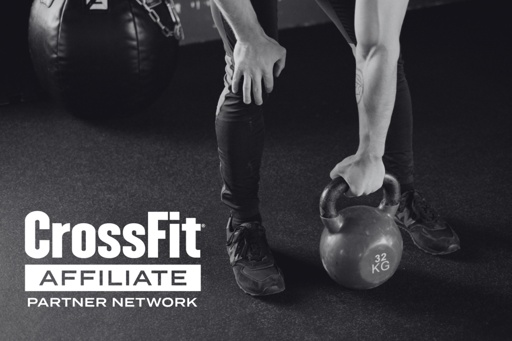 CrossFit Affiliate Partner Network logo on black and white photo of person lifting kettlebell