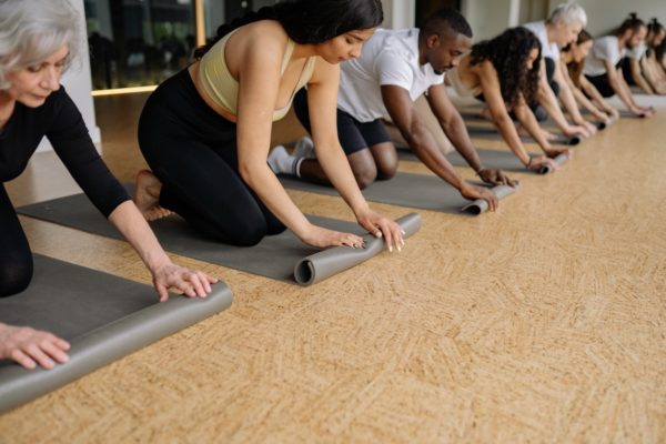 class unrolling their yoga mats