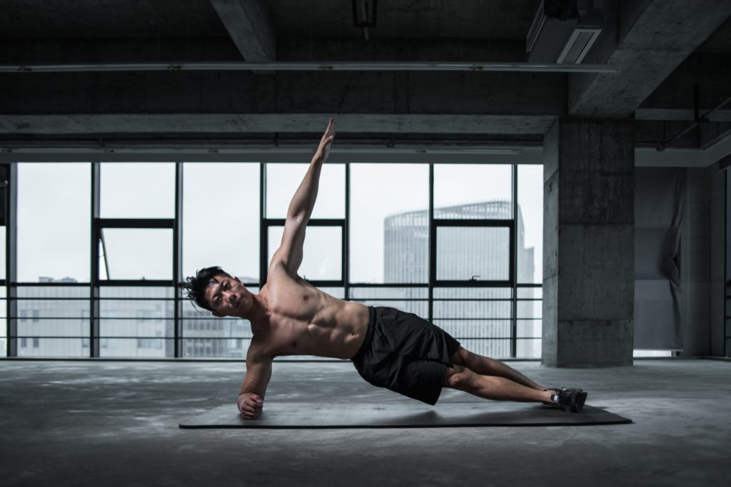 Man doing a side plank on a mat