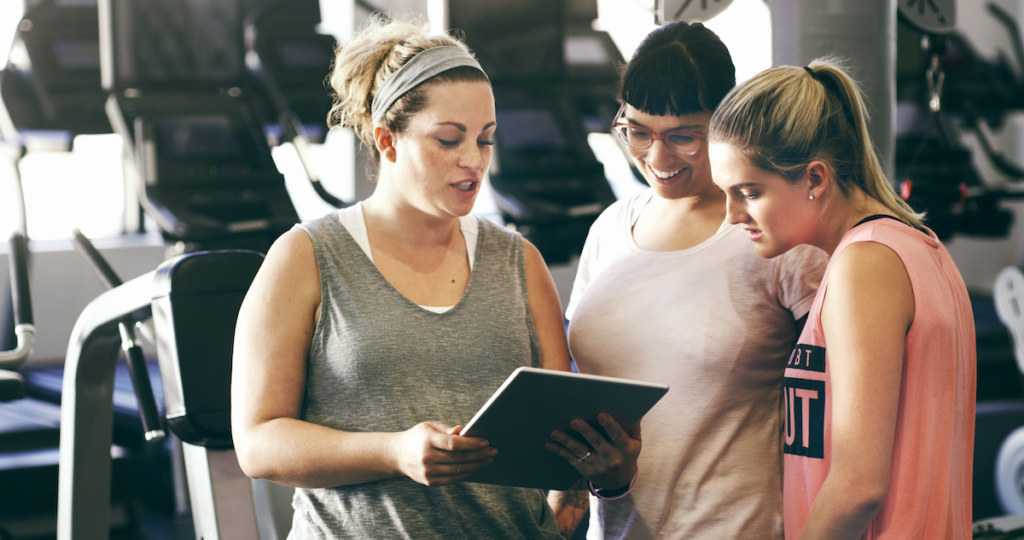 3 women using tablet at gym