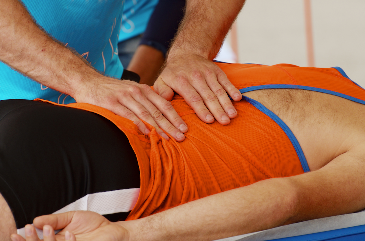 Athlete in orange shirt getting massage