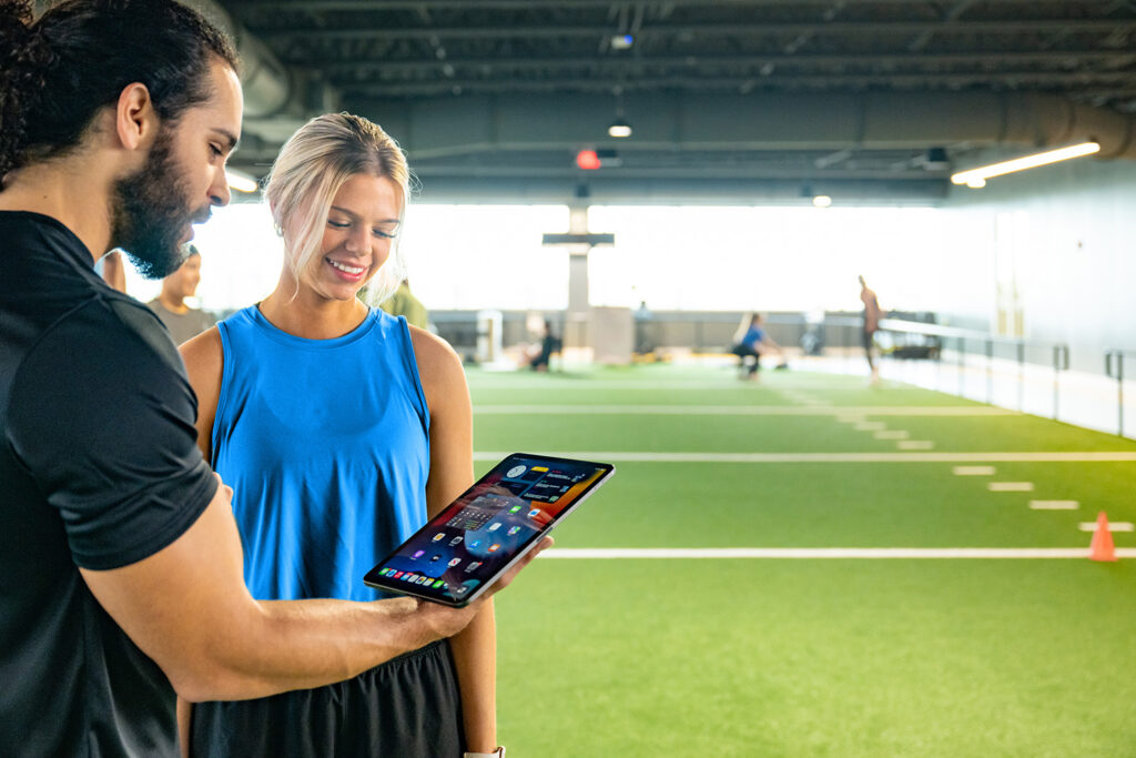 Gym owner reviewing Zen Planner billing dashboard showing automated payments and member invoices