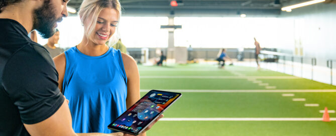 Gym owner reviewing Zen Planner billing dashboard showing automated payments and member invoices