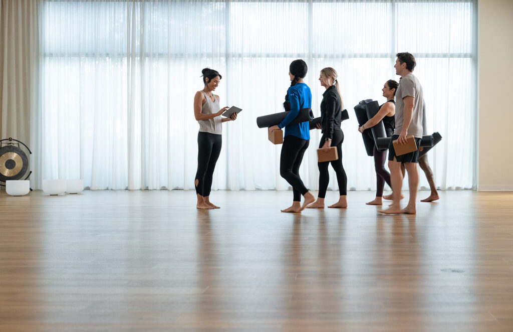 Fitness coach hosting a hybrid workout class using Zen Planner software with both in-person and virtual participants.