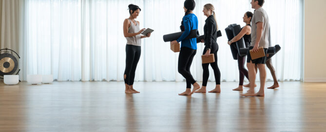 Fitness coach hosting a hybrid workout class using Zen Planner software with both in-person and virtual participants.