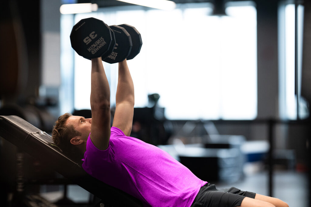 Gym owner reviewing Zen Planner’s best class scheduling software on their device.
