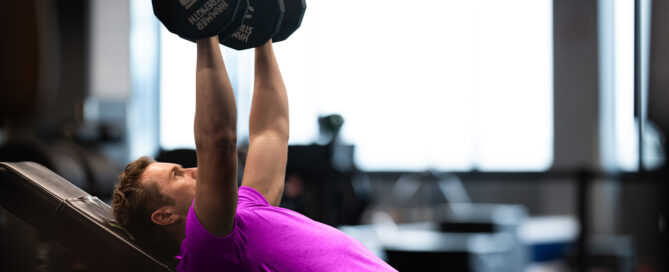 Gym owner reviewing Zen Planner’s best class scheduling software on their device.
