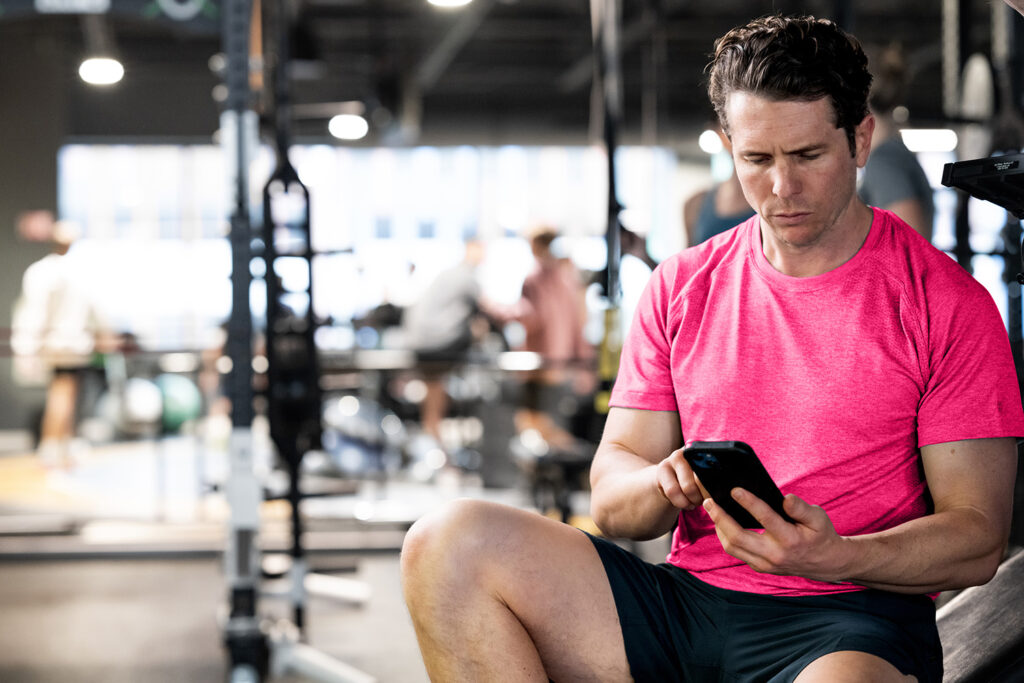 Fitness coach using Zen Planner’s top class scheduling software on a tablet in a boutique studio.
