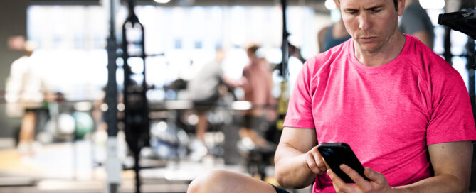 Fitness coach using Zen Planner’s top class scheduling software on a tablet in a boutique studio.