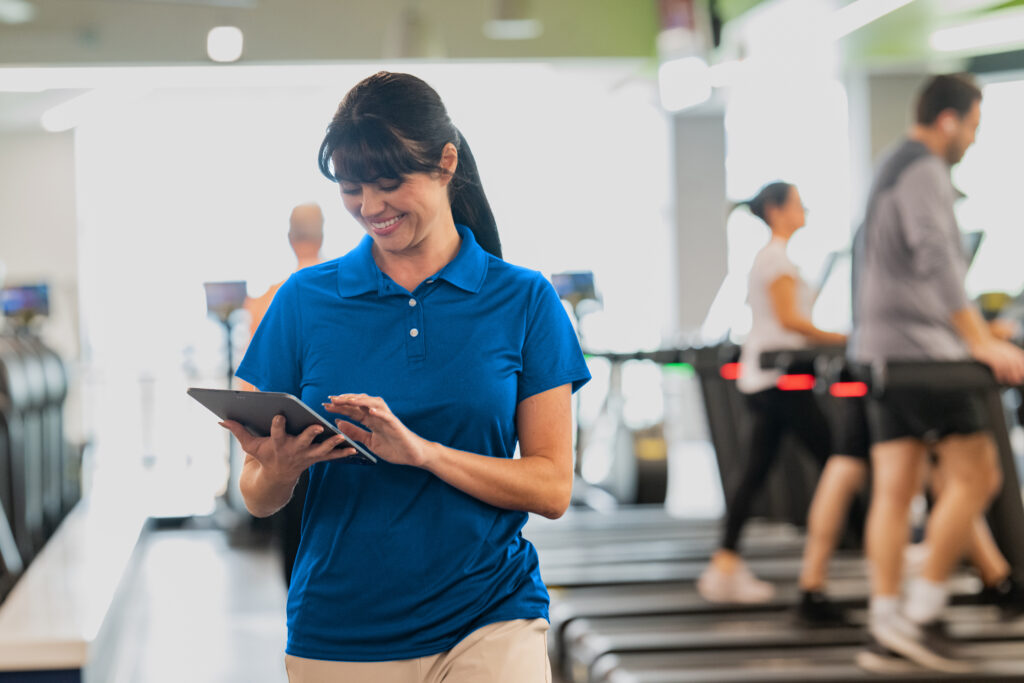 Small gym owner reviewing Zen Planner billing dashboard on an ipad