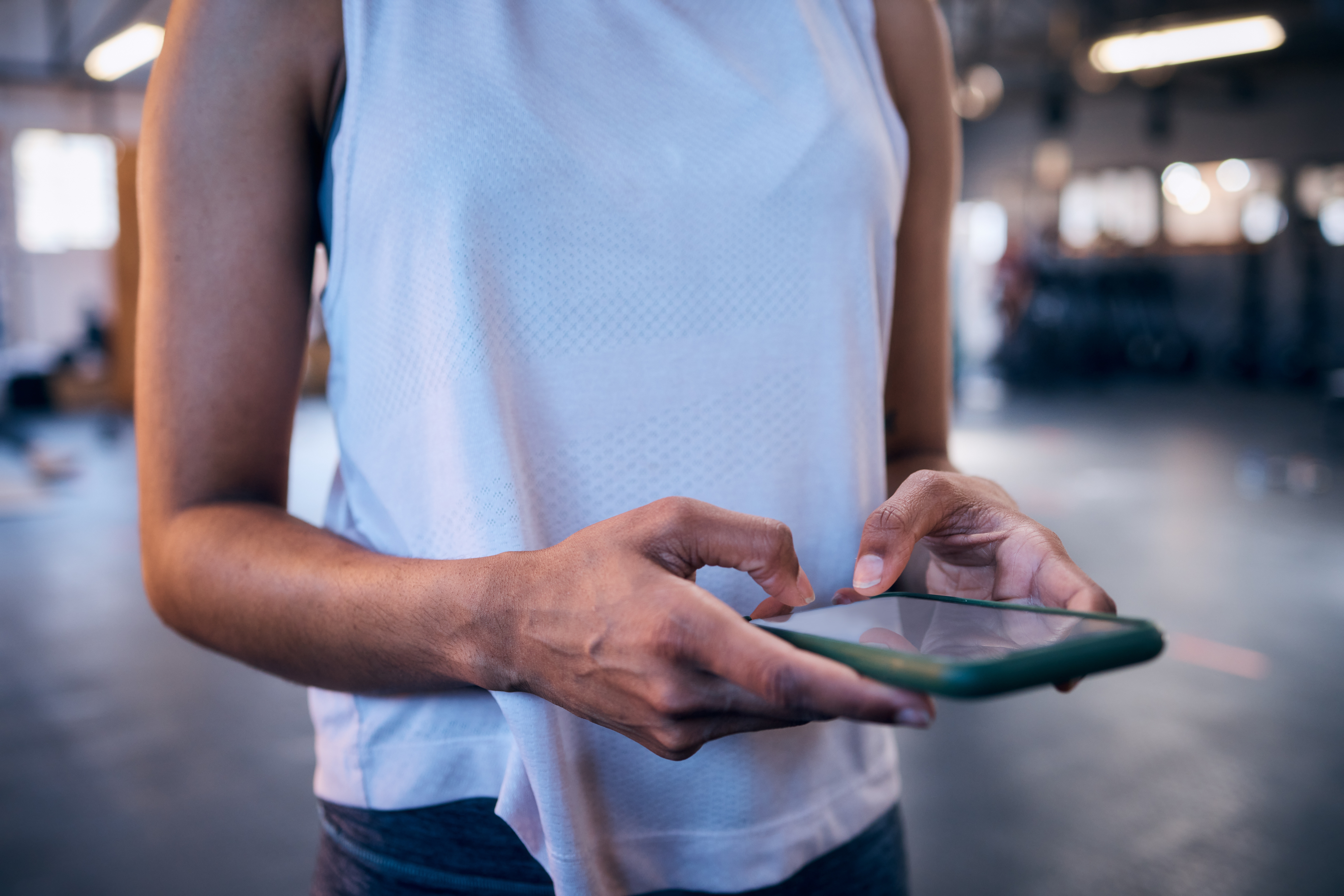 Woman,,Hands,Or,Phone,Typing,In,Gym,For,Workout,Management Fitness studio owner comparing software platforms on a tablet