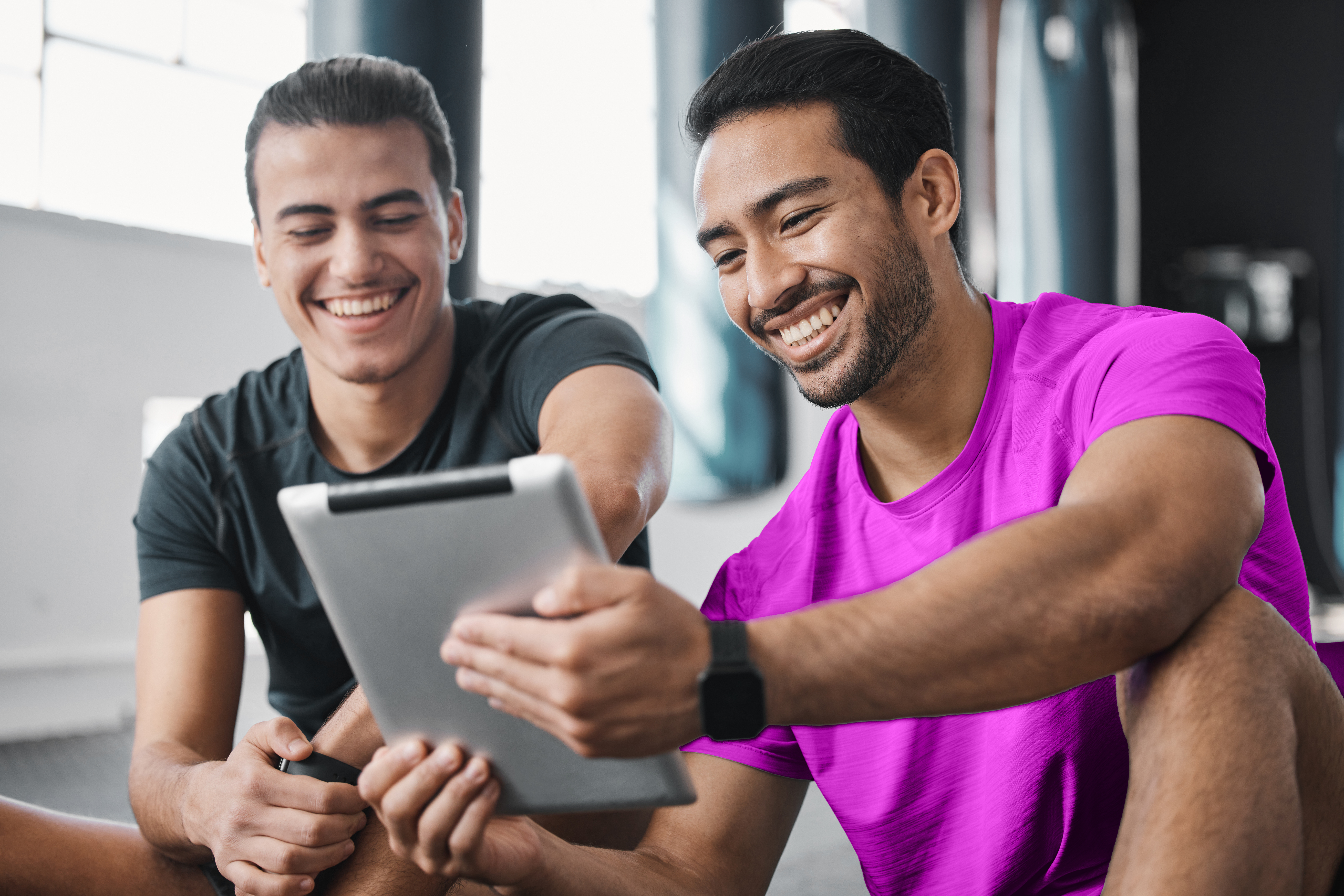 A gym owner and a colleague attending a webinar online for fitness business.