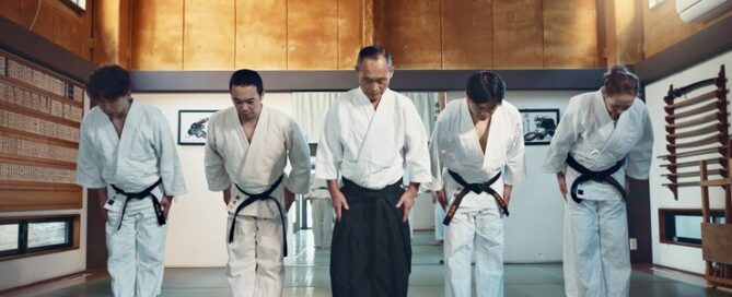 Martial arts instructor and students bowing respectfully at the beginning of a dojo training session
