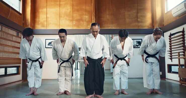 Martial arts instructor and students bowing respectfully at the beginning of a dojo training session