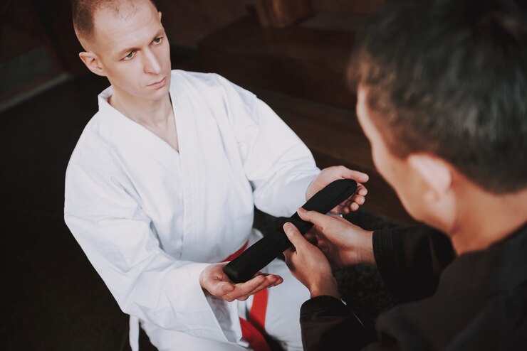 Martial Arts Student Receiving a Black Belt During a Promotion Ceremony