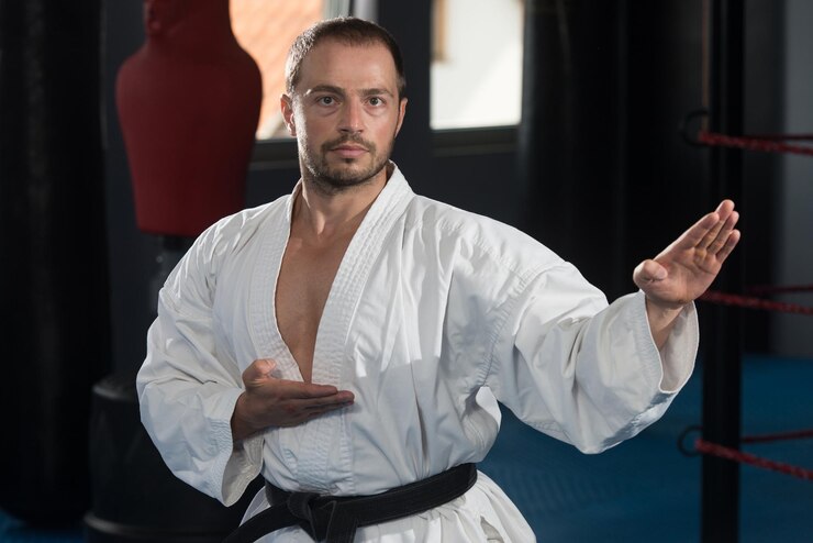 Martial Artist in a White Uniform Practicing a Kata Pose in a Dojo