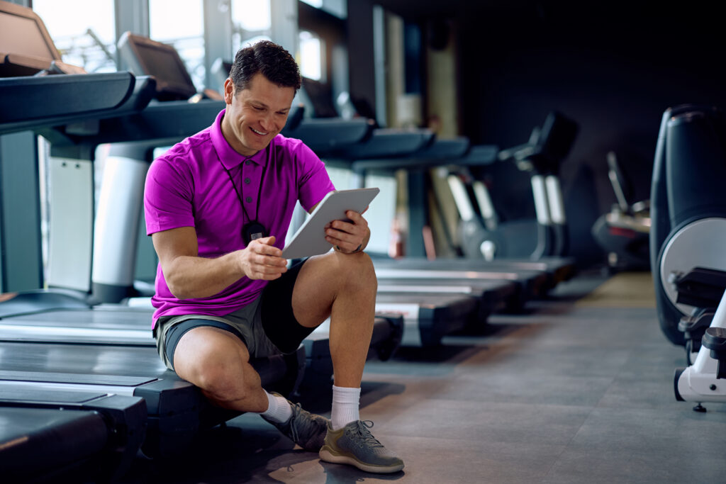 Gym owner reviewing member retention analytics on management software