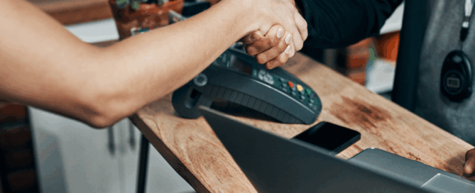 front desk handshake with computer and phone