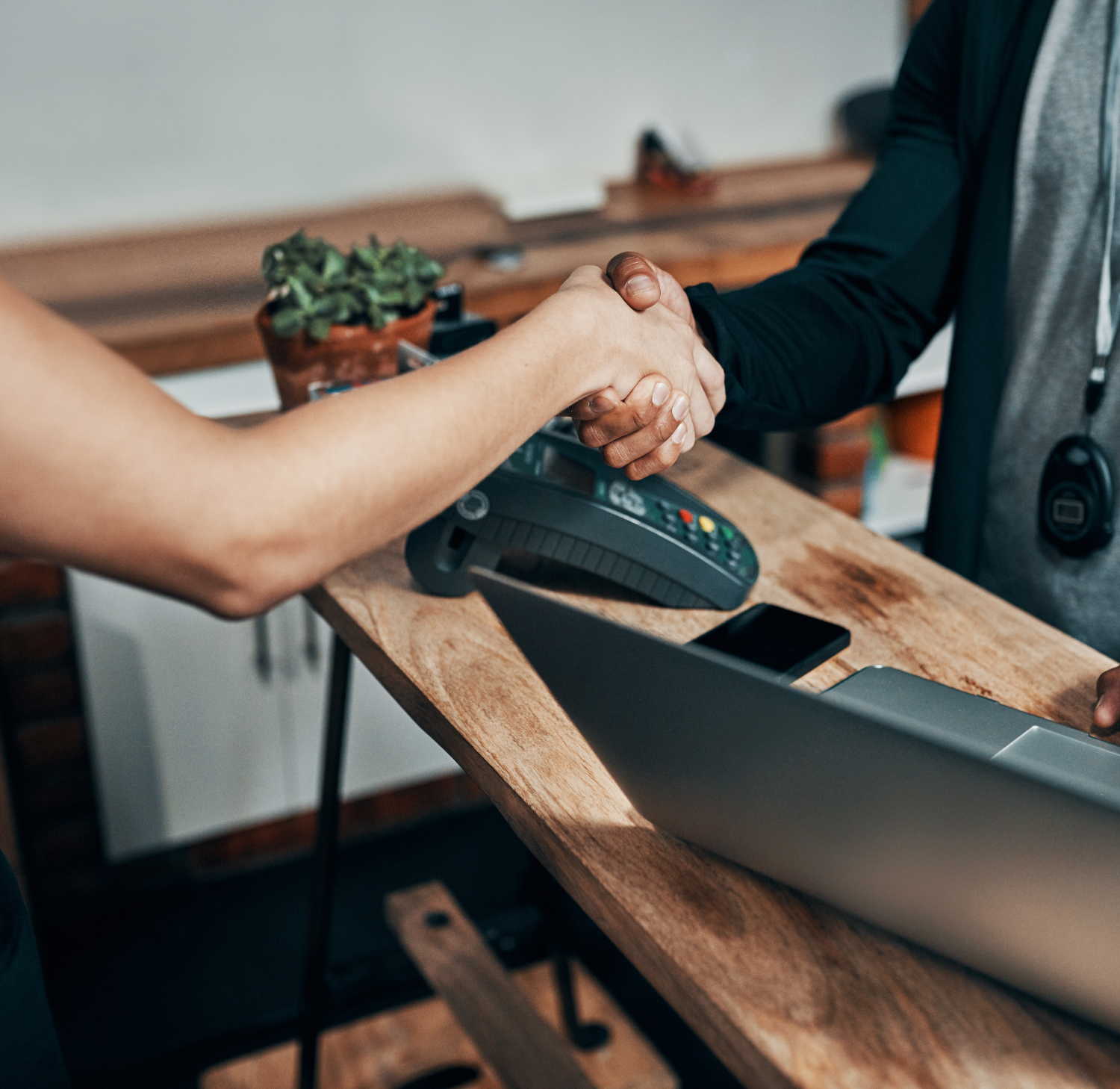 front desk handshake with computer and phone