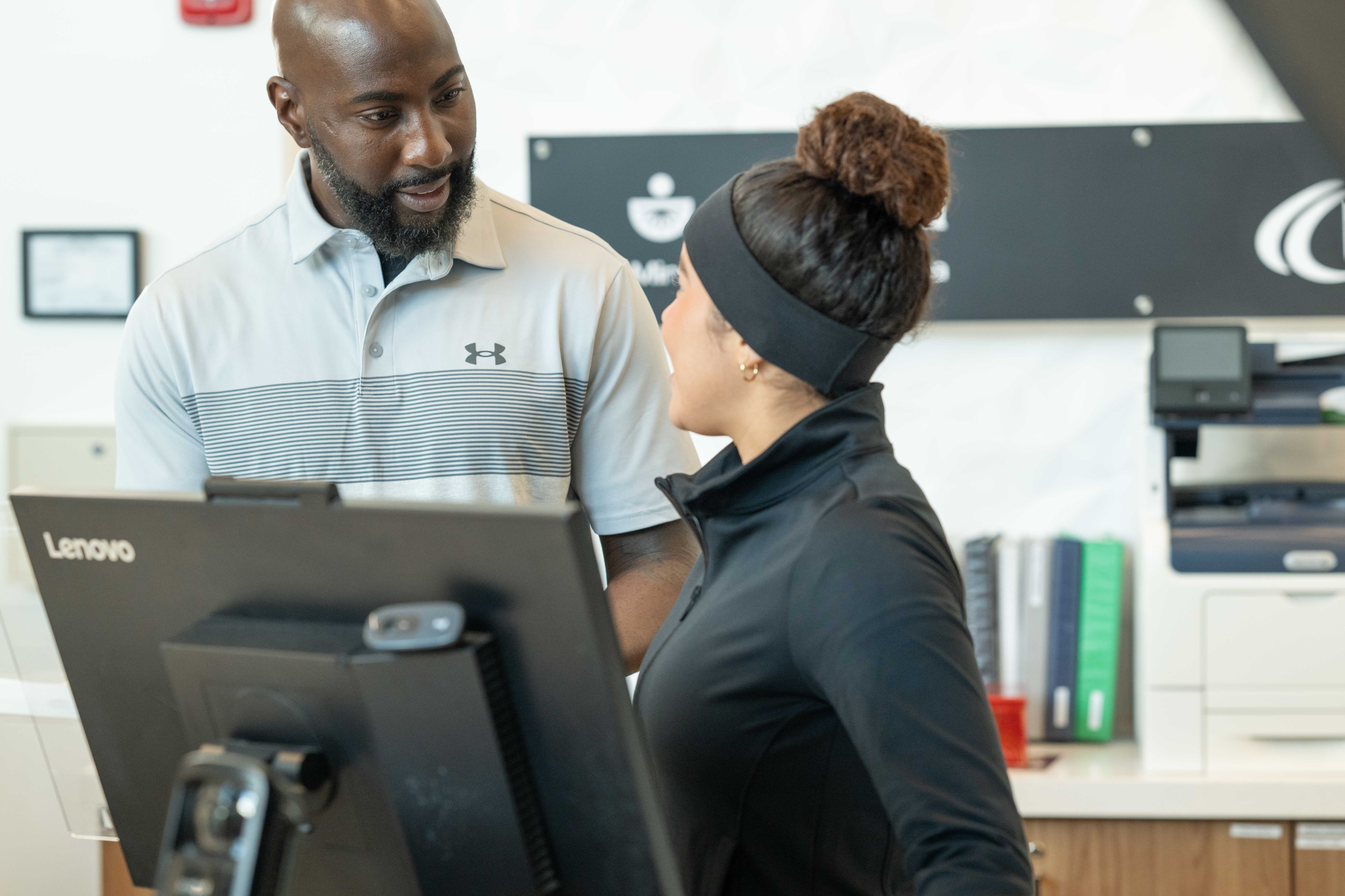 Gym staff using management software at the front desk