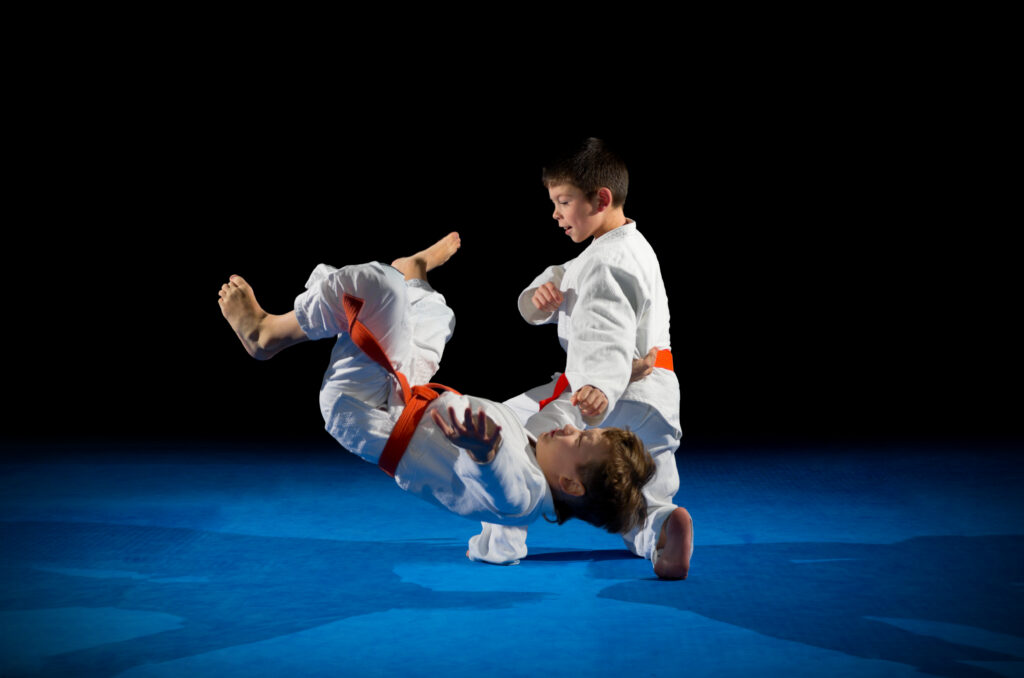 Martial arts students training in a dojo with an instructor tracking their progress