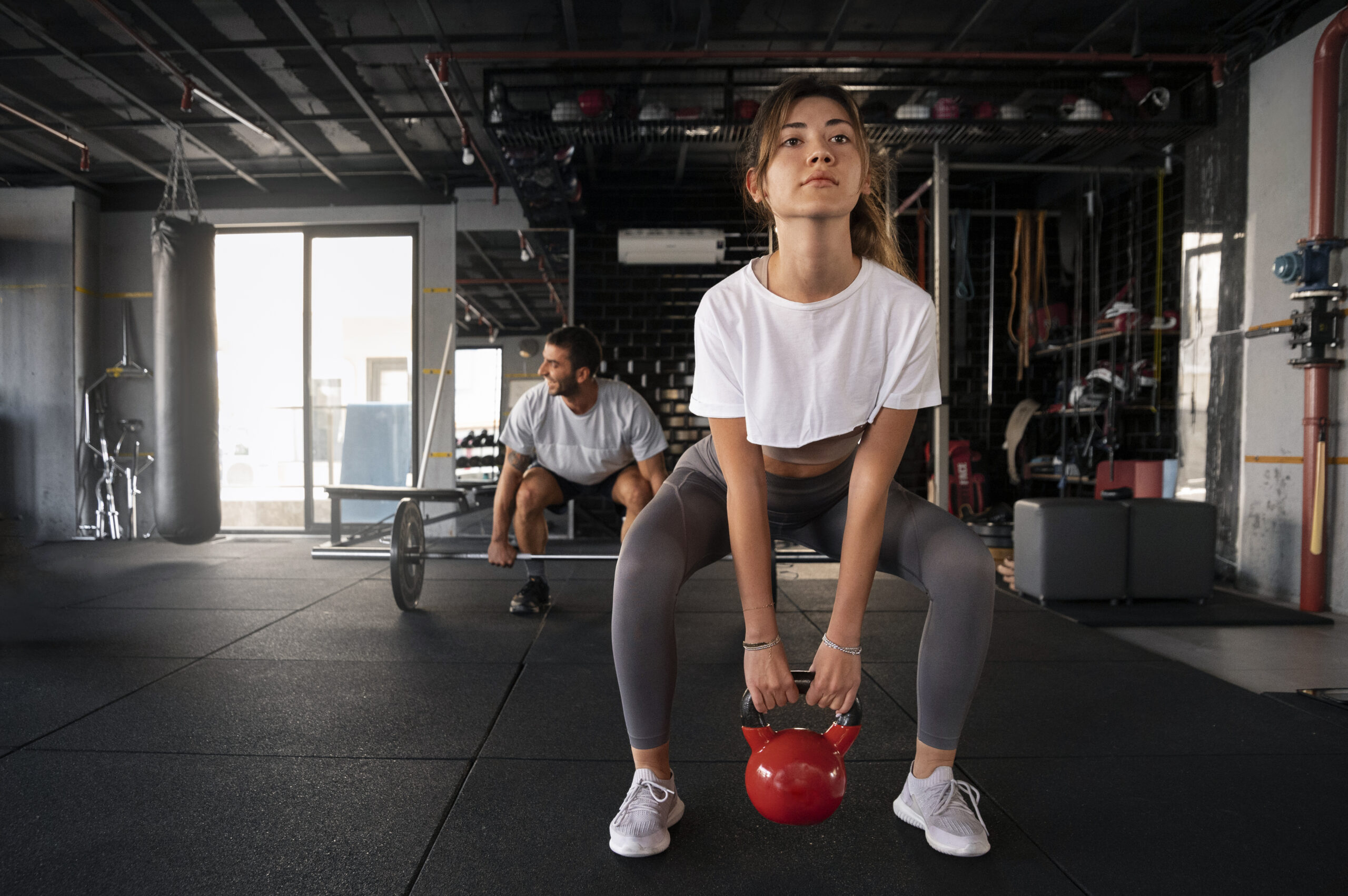 Focused gym workout with kettlebell and barbell training