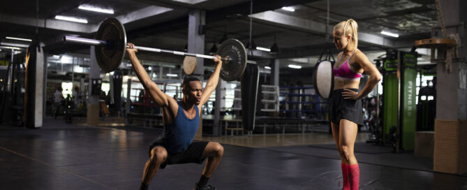 Woman training a man at a gym