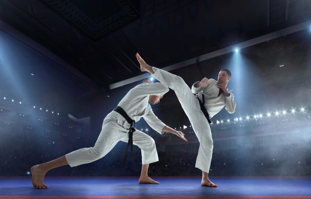 Karate fighters sparring with a high kick in a martial arts competition
