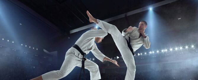 Karate fighters sparring with a high kick in a martial arts competition