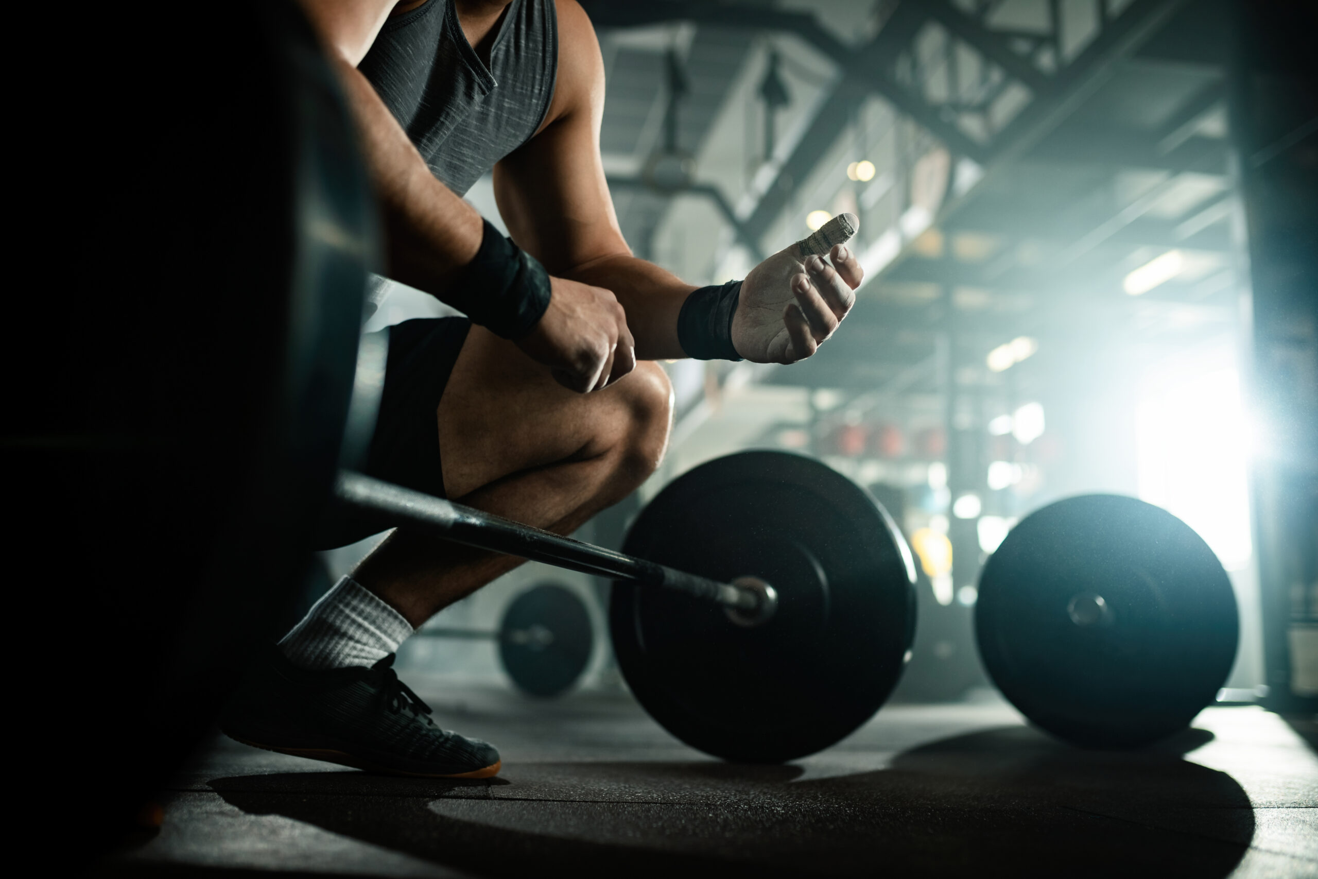 Athlete preparing for deadlift with a barbell in a gym