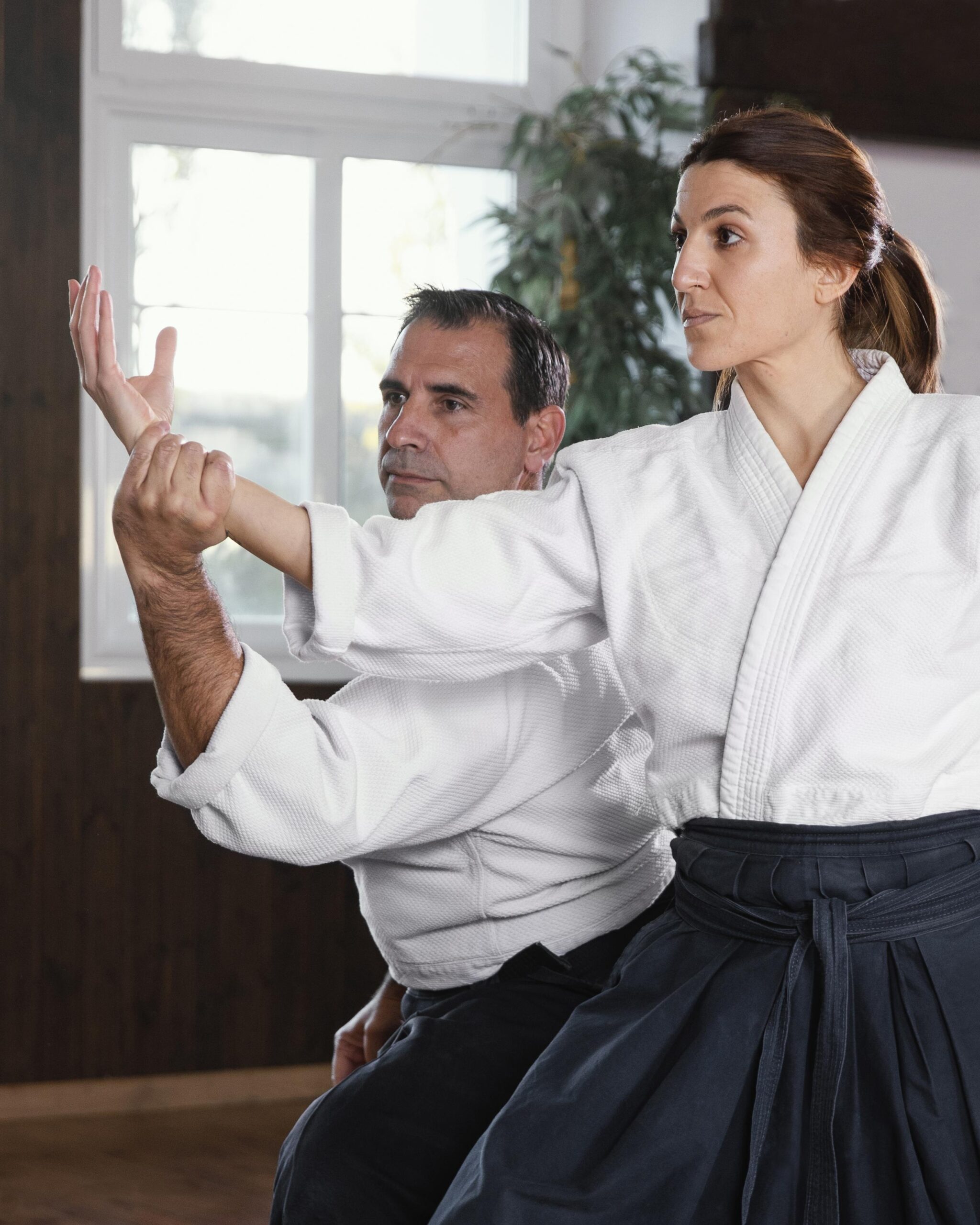 Martial arts instructor guiding a student during a trial session