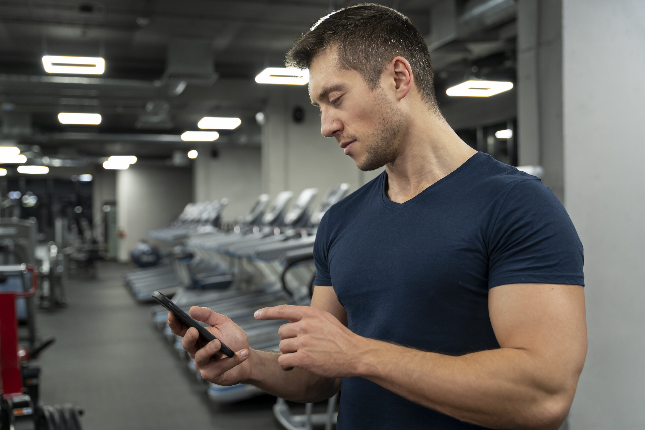 Young adult using a gym member app at a gym