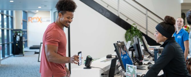 Trainer using fitness studio management software at a boutique fitness studio