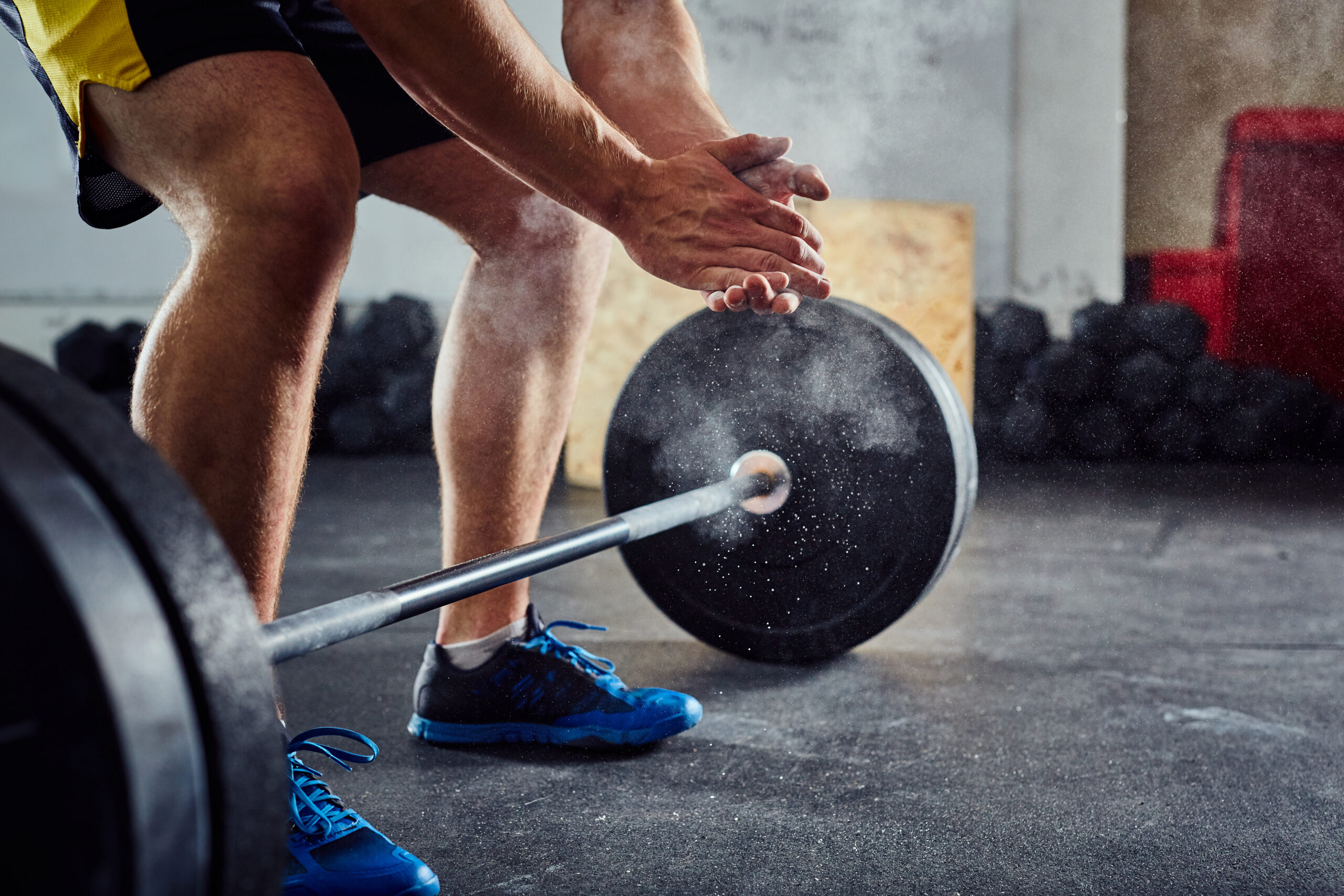 Weightlifter clapping hands before workout with barbell at the g Member syncing calendar with gym booking software