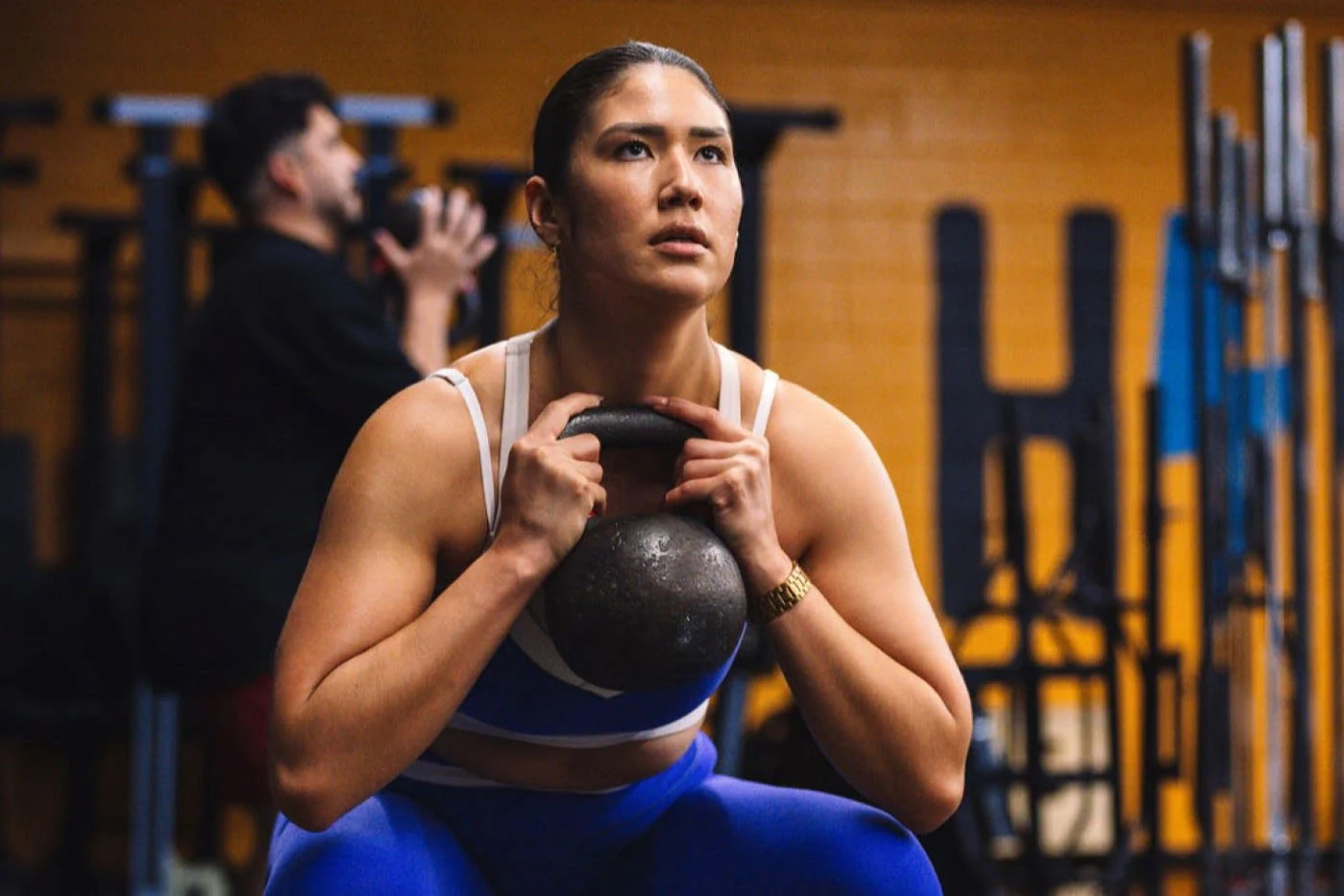 A female athlete working out with a kettleball at the CrossFit High Voltage facility.