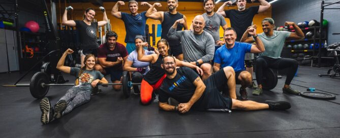 Coach leading a CrossFit class while using gym management software to automate operations