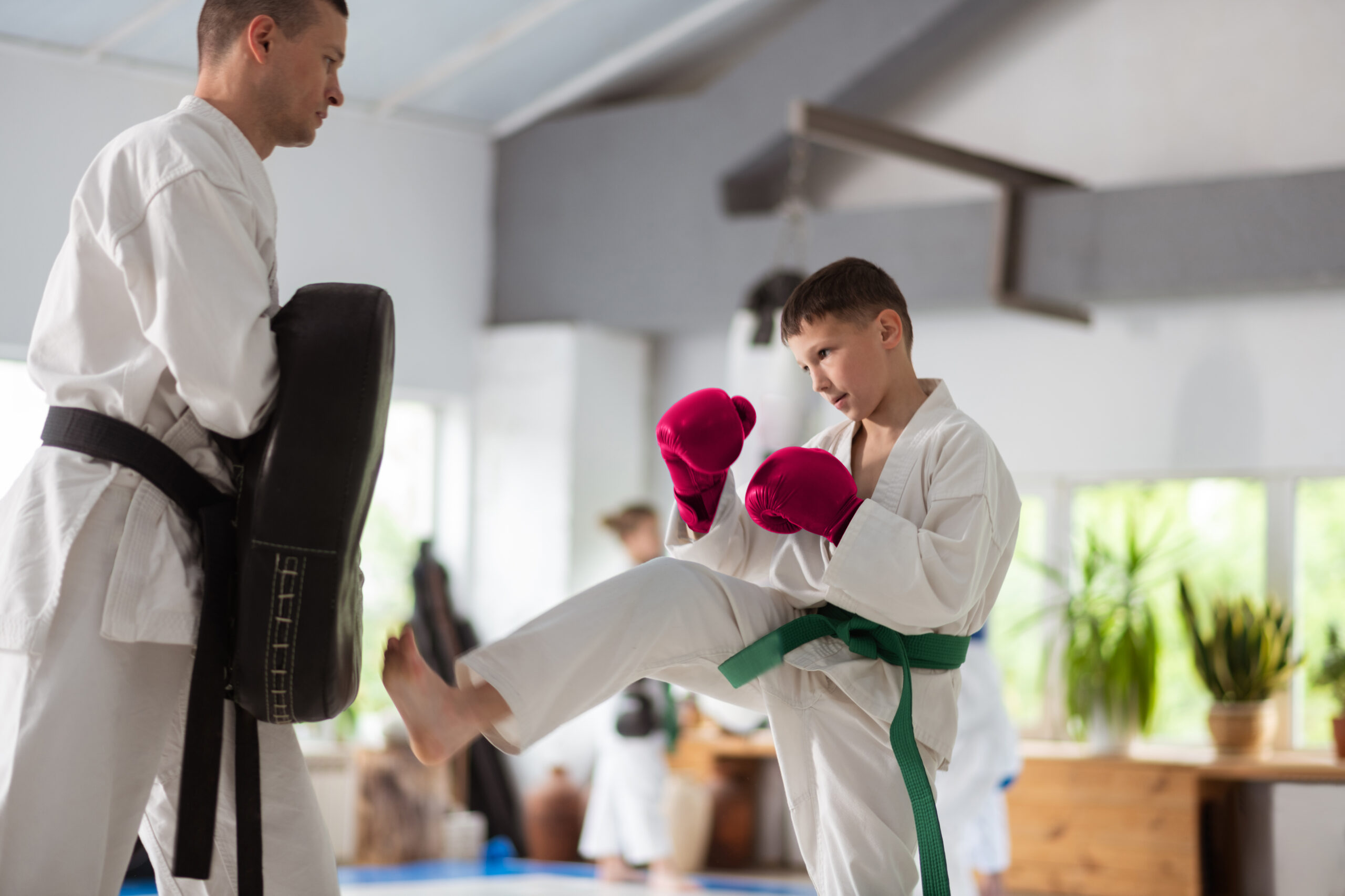 A student practicing martial arts in a class with his instructor.