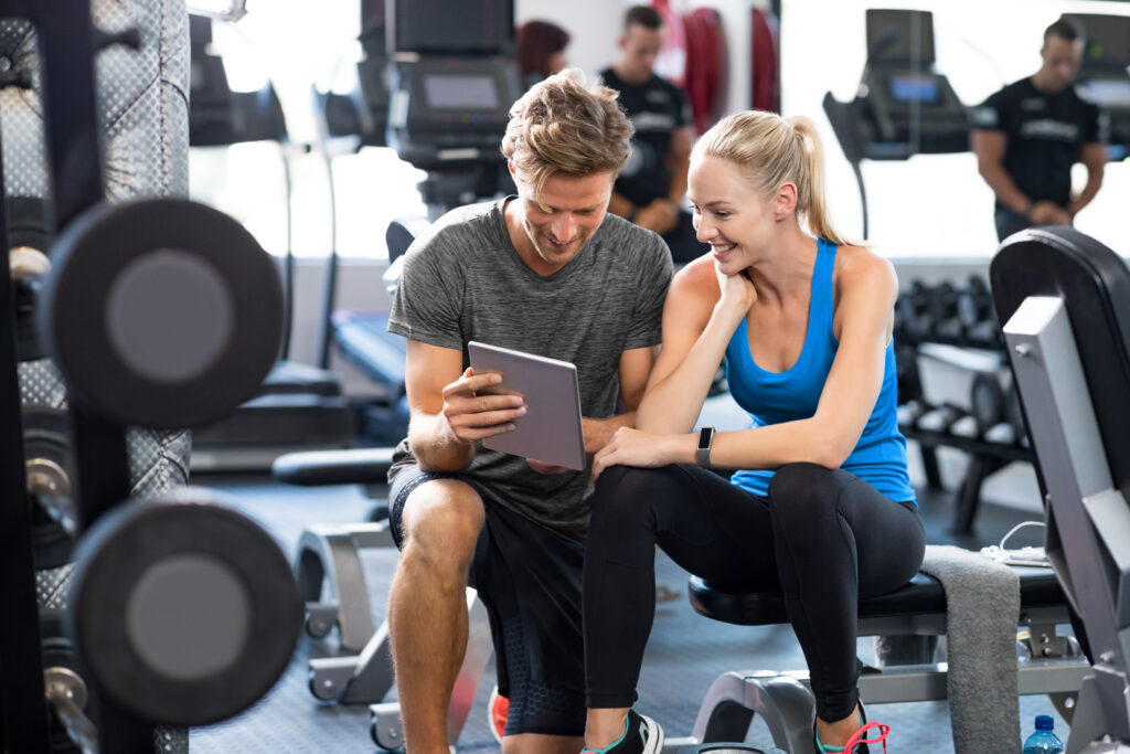 A gym owner planning class schedules and business strategy in a modern fitness facility