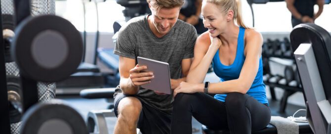 A gym owner planning class schedules and business strategy in a modern fitness facility