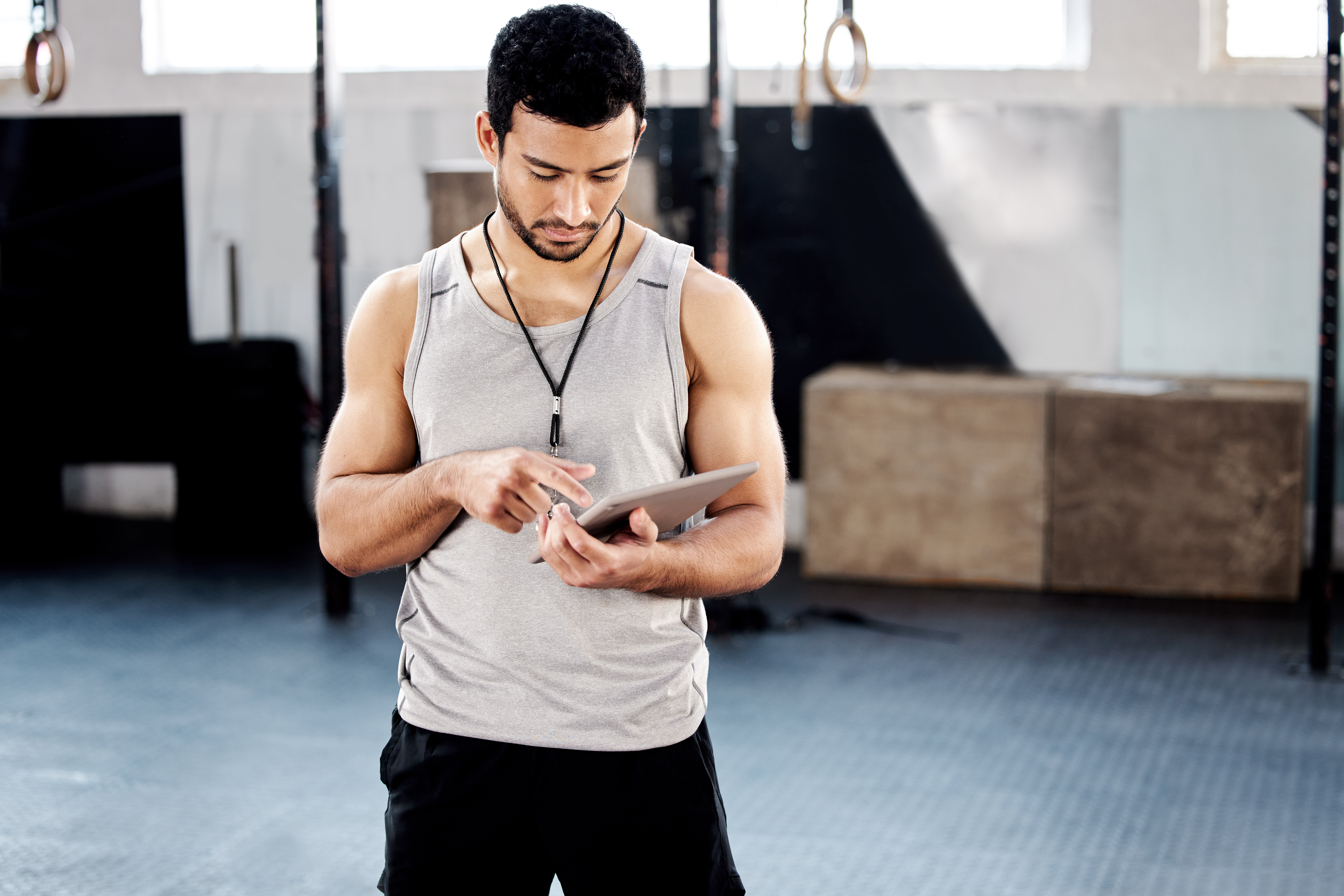 Ill keep a close eye on my clients. Shot of a handsome young man using a digital tablet at the gym. A gym owner helping his gym members online effortlessly.