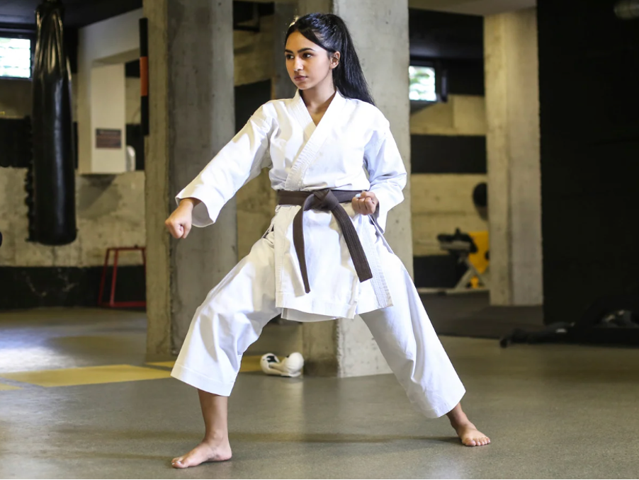 A female martial arts student in between a training session.