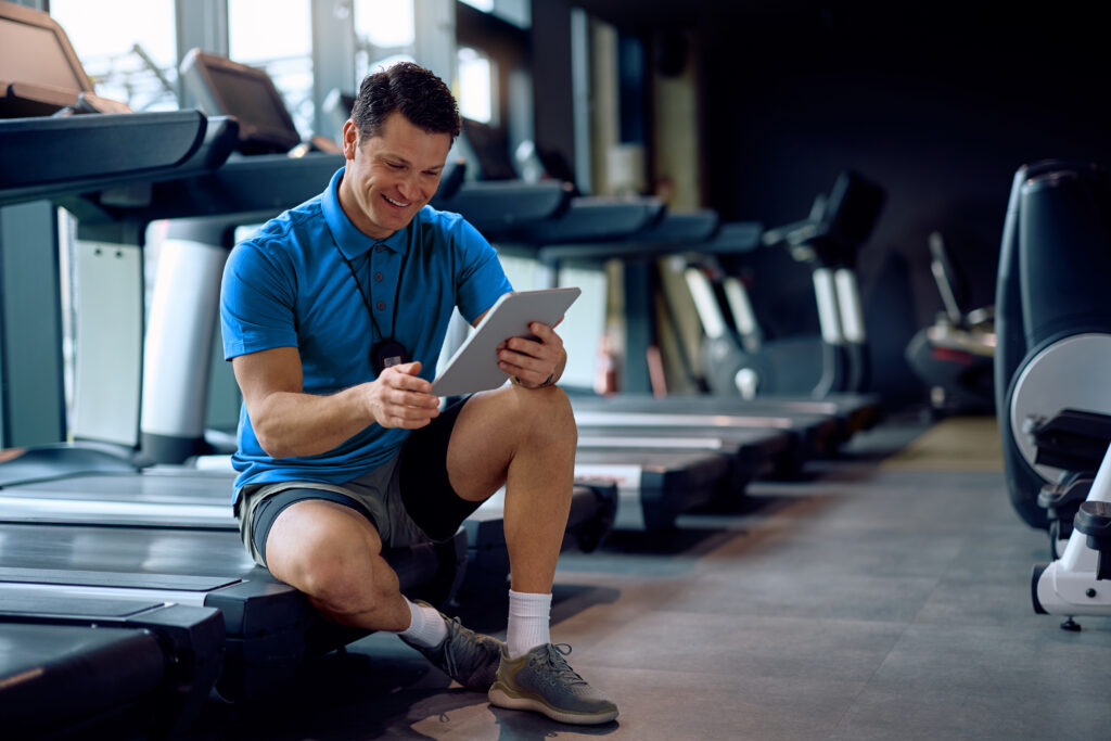 gym owner using a gym management system to manage schedules, memberships, and billing