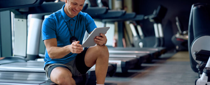 gym owner using a gym management system to manage schedules, memberships, and billing