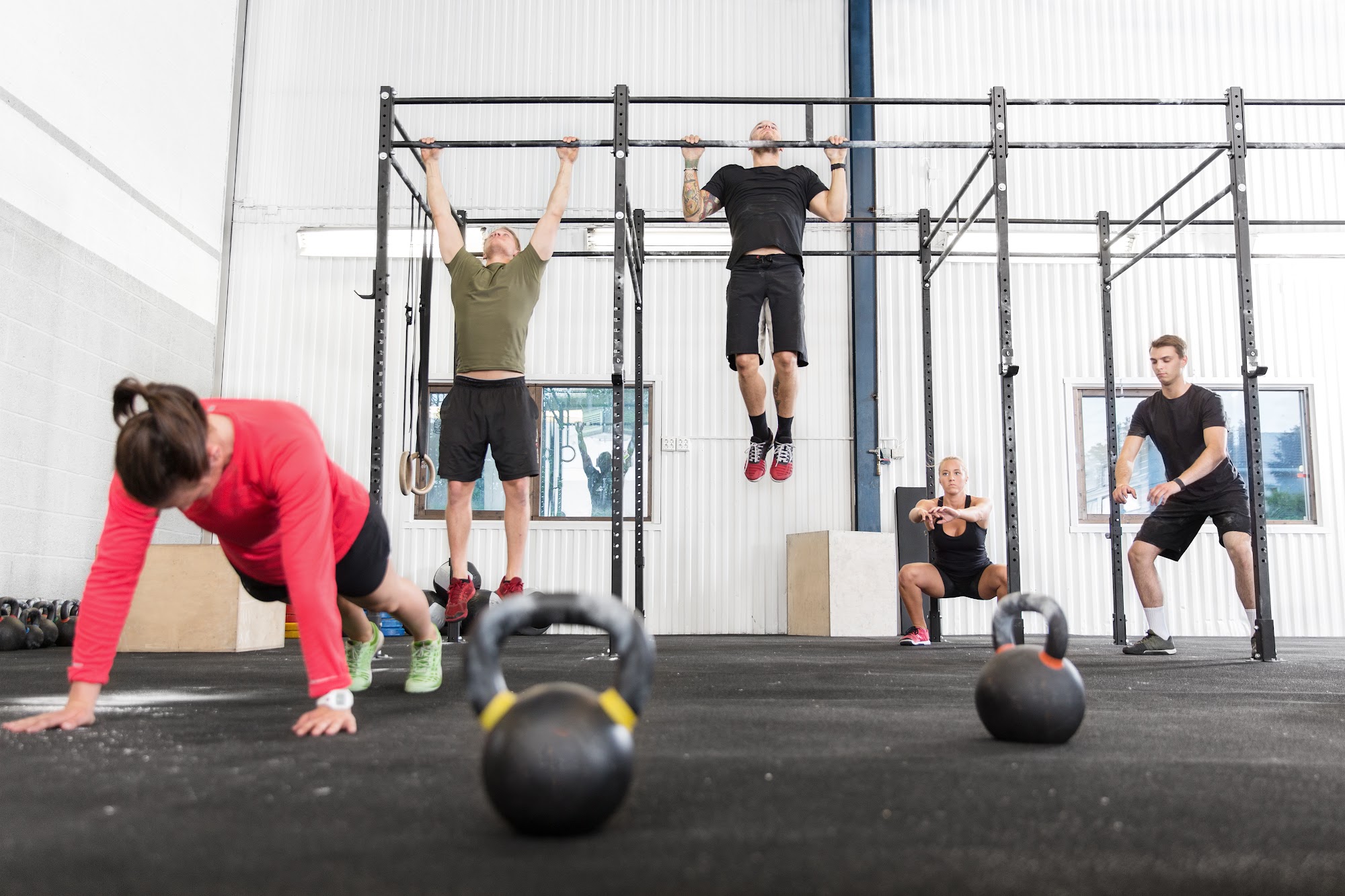Trainer leads CrossFit class, illustrating gym management with software