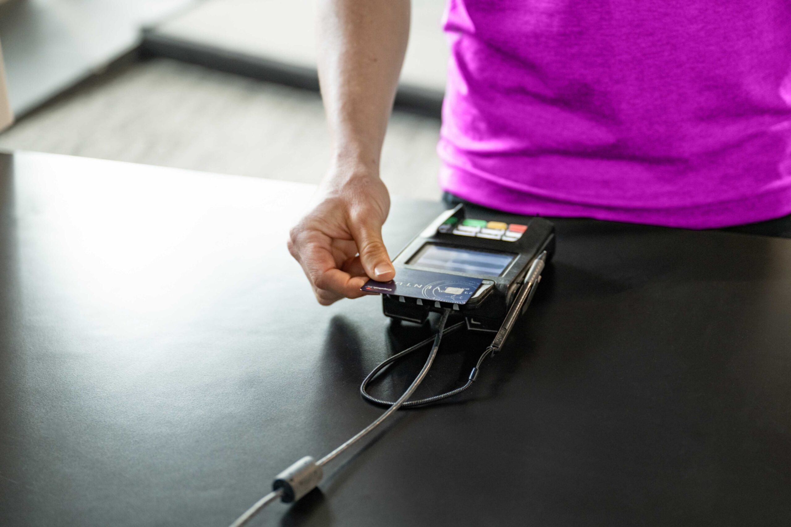 A man processing payment via his credit card inside a boutique gym.